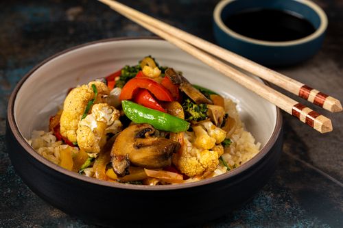 Free Close-up of a vibrant vegetable rice bowl with mushrooms and chopsticks. Stock Photo