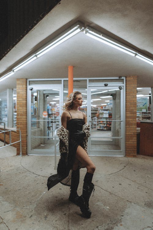 Stylish Woman in Front of Building at Night