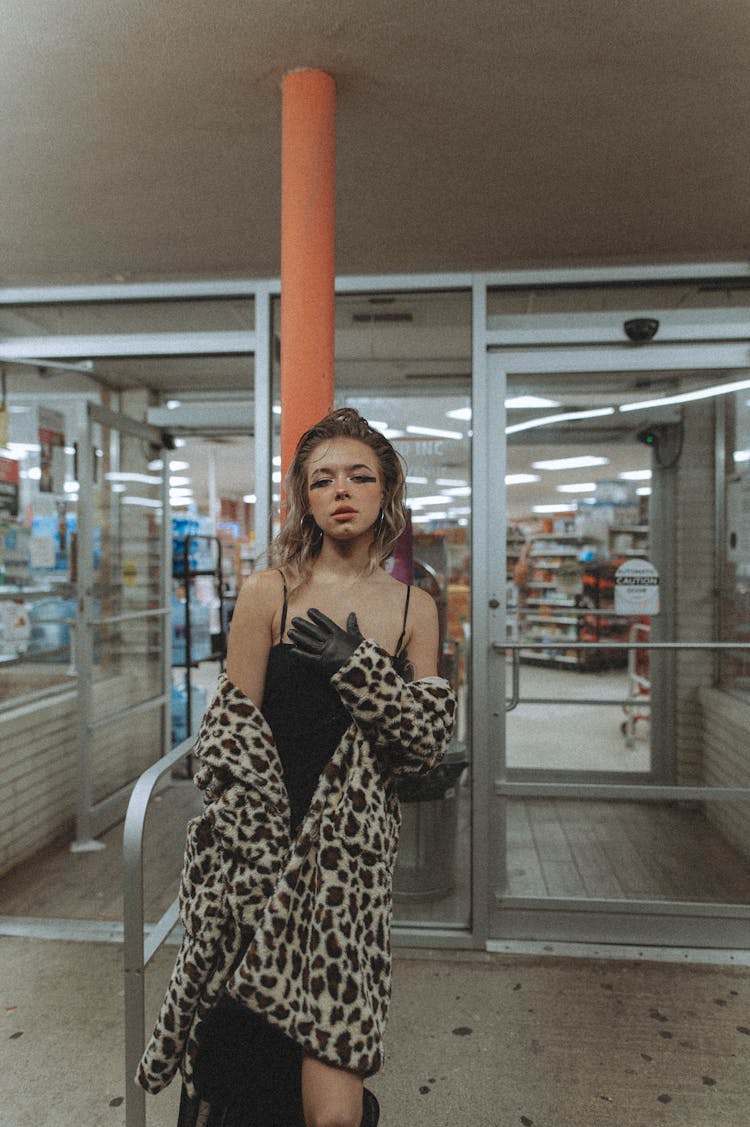 Stylish Woman In Front Of Building At Night