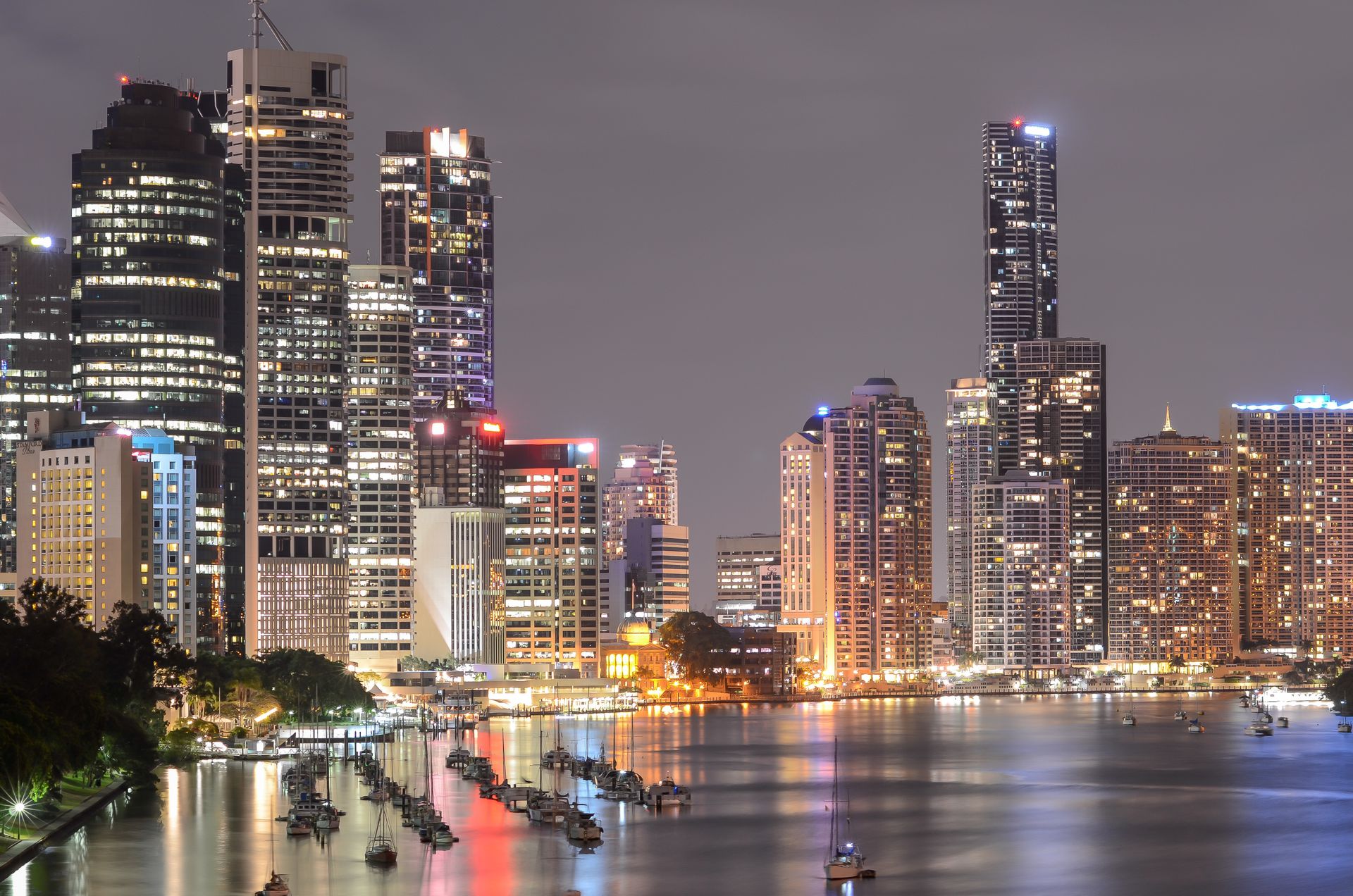 A breathtaking view of Brisbane's illuminated skyline at night with reflections on the river.