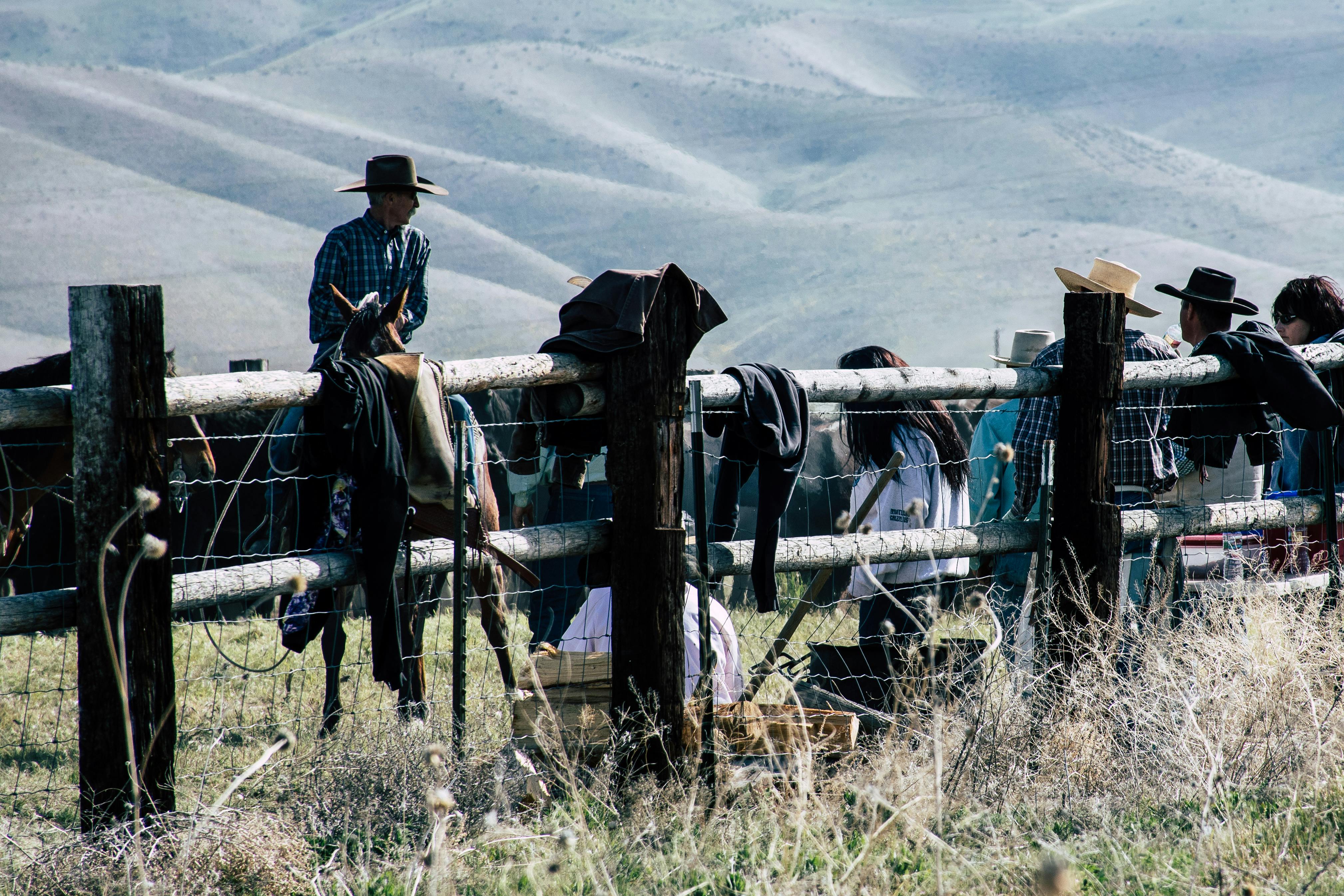 Cowboys Leaning on Brown Fence · Free Stock Photo