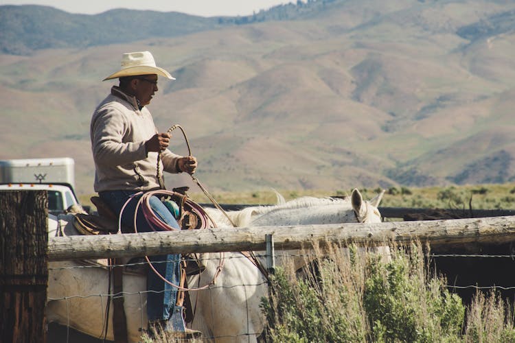 Photo Of Man Riding On White Horse