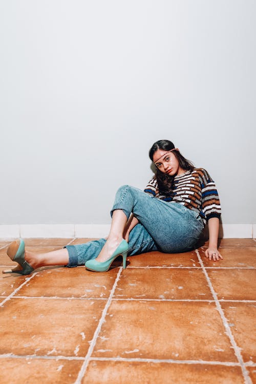 A Woman Wearing Blue Heels while Sitting on the Floor 