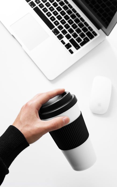 Person Holding a Disposable Cup