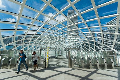 Free People walking under a stunning glass dome with modern urban skyline in the background. Stock Photo
