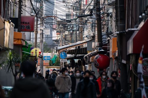 Free Busy street in Osaka, Japan featuring masked pedestrians during daytime. Urban life captured. Stock Photo