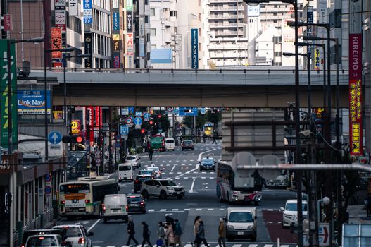 A vibrant urban scene in Osaka, Japan, showcasing bustling traffic and city life on a busy street.