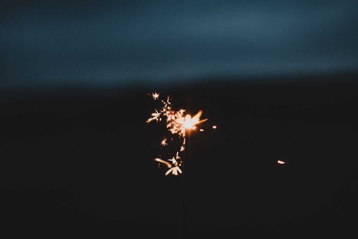 A sparkler burning brightly against a dark background — photo by David Selbert on Pexels