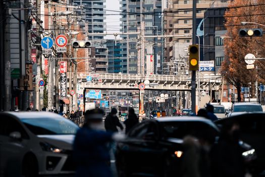 Explore the busy streets of downtown Osaka, Japan, a vibrant urban scene filled with people and vehicles.