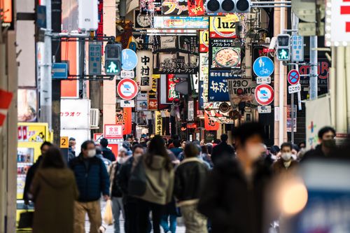 Free Bustling street in Osaka filled with signs and people, capturing the urban vibrancy of Japan. Stock Photo