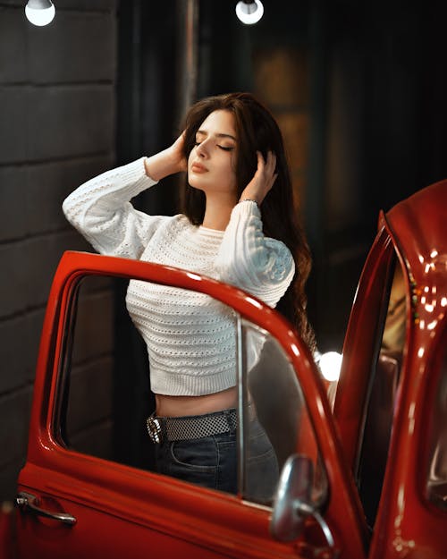 Woman in White Sweater Exiting Red Car