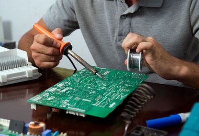Technicien soudant une carte