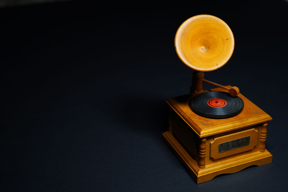 Old-fashioned gramophone with wooden base and vinyl record.