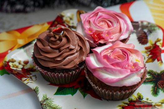 Close-up of beautifully decorated cupcakes with rose and chocolate frosting on a festive platter.