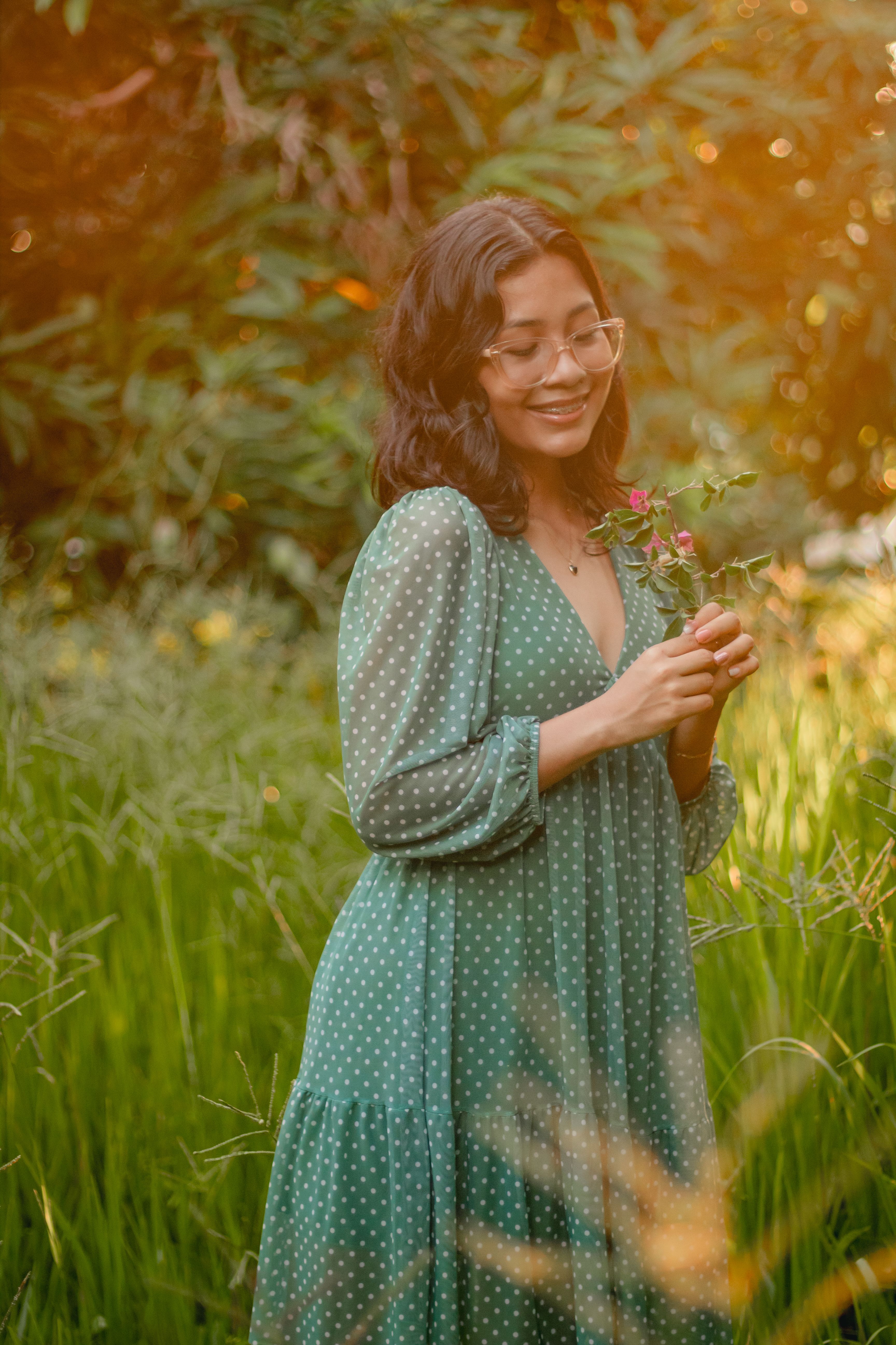 A Woman in Polka Dot Dress Standing on Green Grass Field · Free Stock Photo