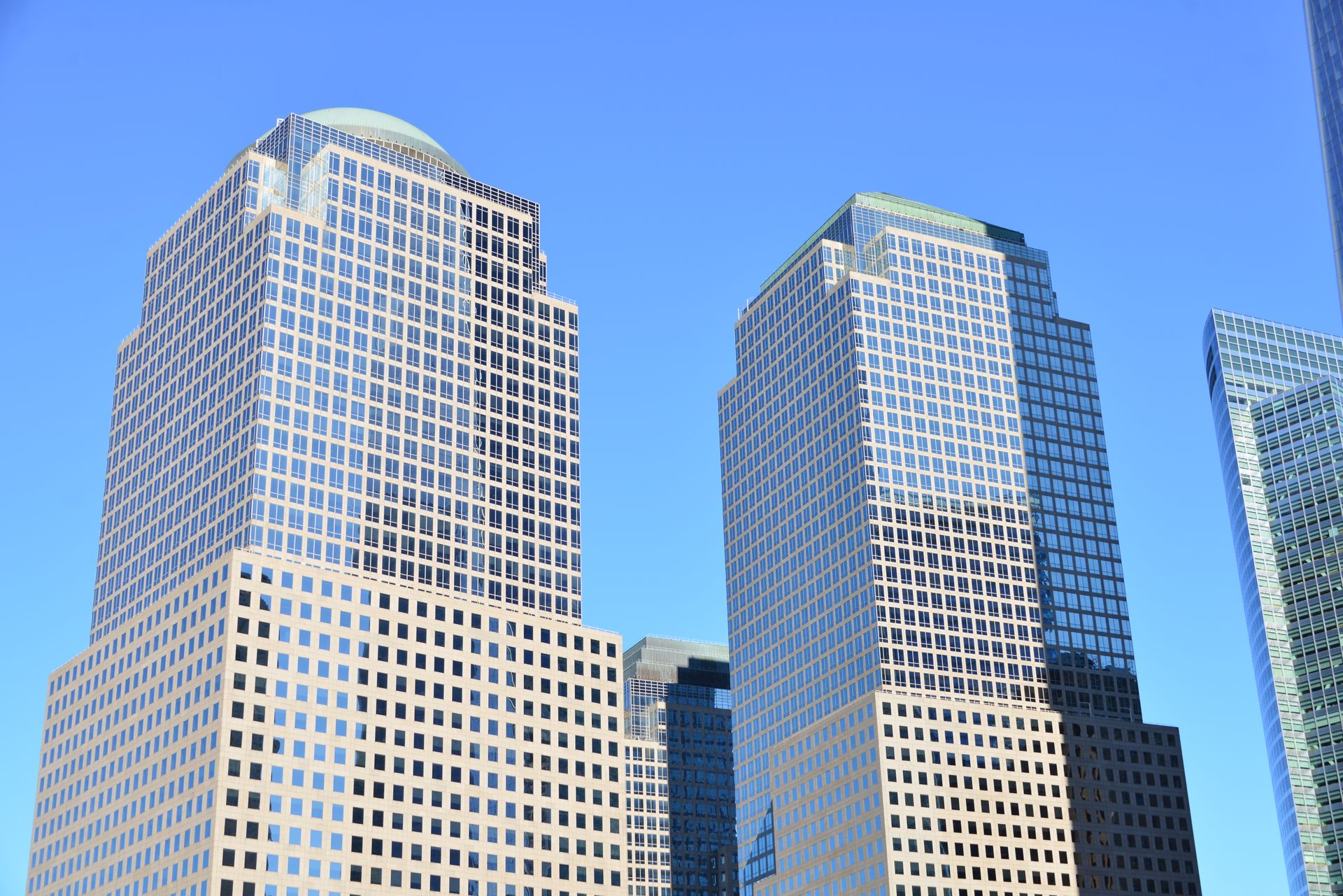 Bright daylit view of modern NYC business district skyscrapers against clear blue sky