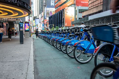 Free Citi Bikes neatly arranged on a busy street in Times Square, New York City. Stock Photo