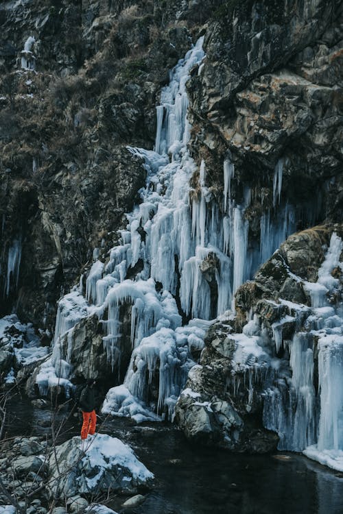 Person near Frozen Rocks over Lake