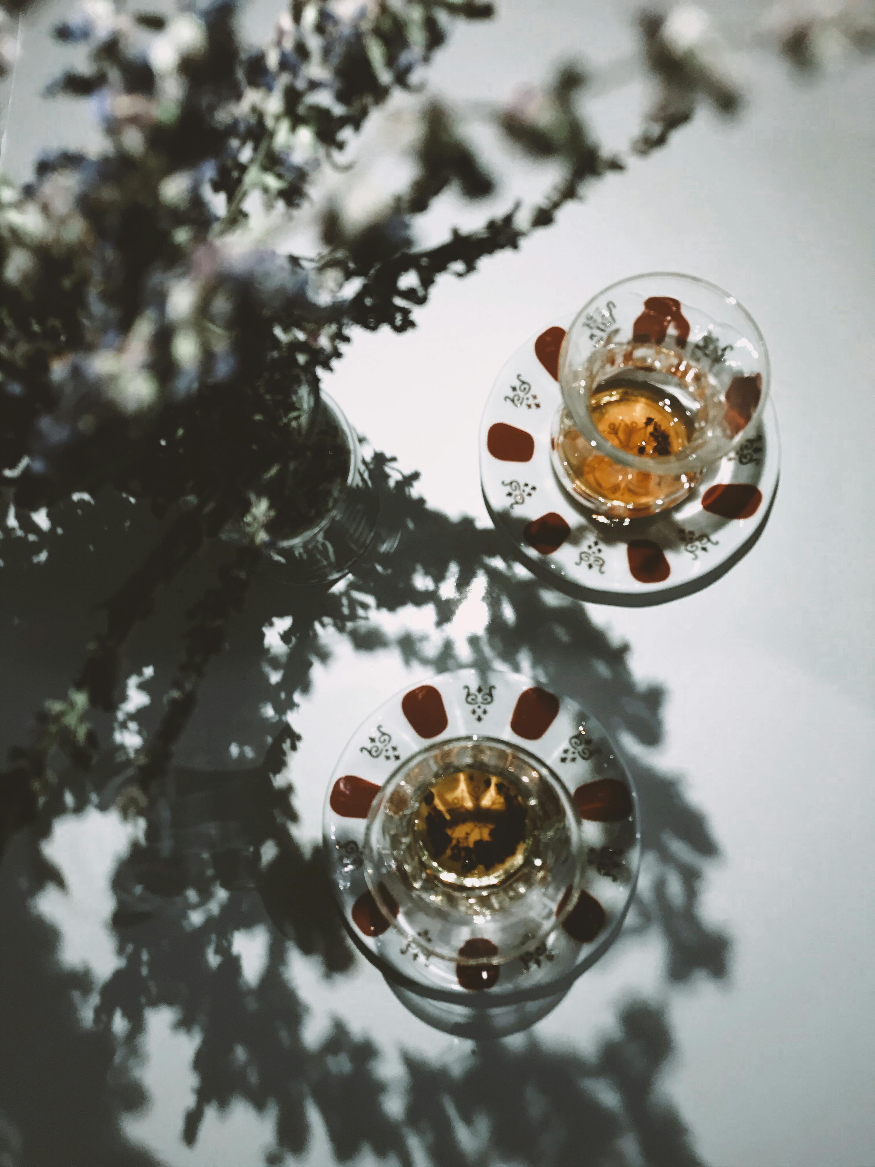 Artistic top-down view of tea cups on saucers, creating intricate shadows for a moody still life.