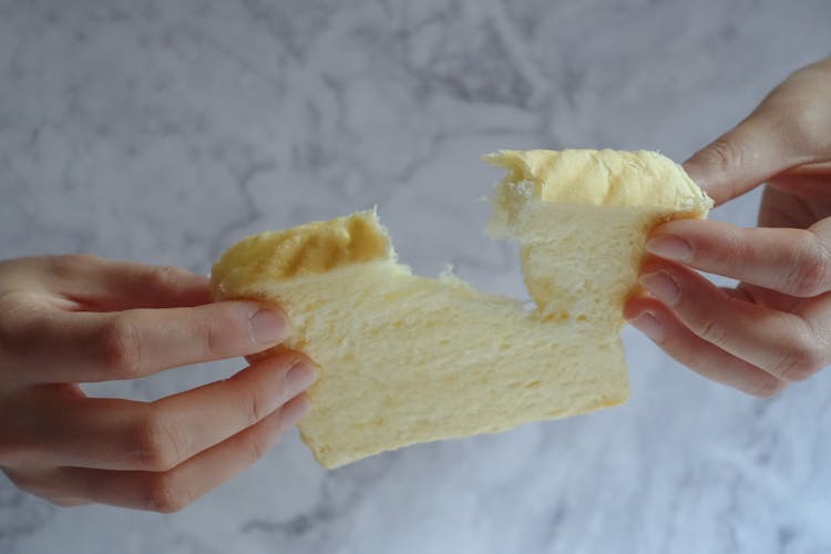 Person Holding Slice Of Loaf Bread