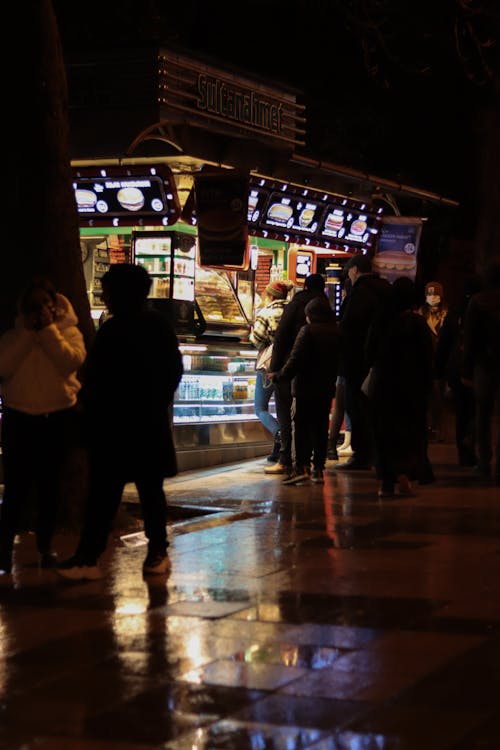 People near Street Food Shop at Night