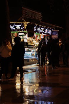 People gathered at a lively street food stall during nighttime in an urban setting.