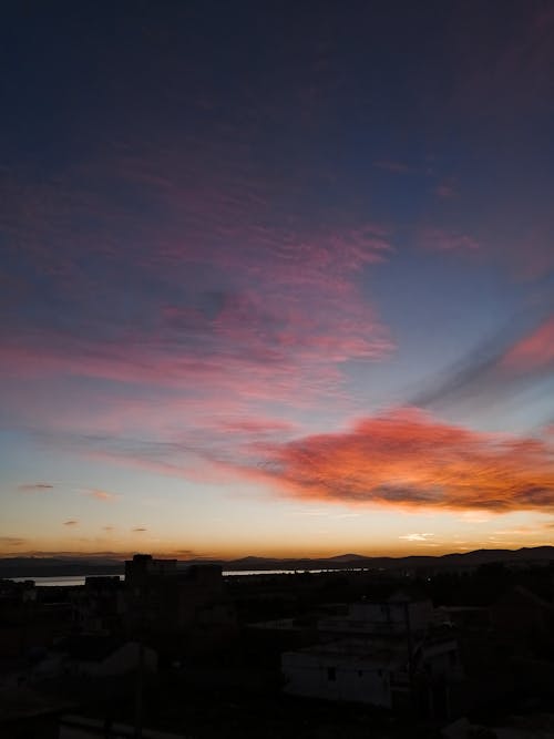 Silhouette of Buildings Under Orange and Blue Sky