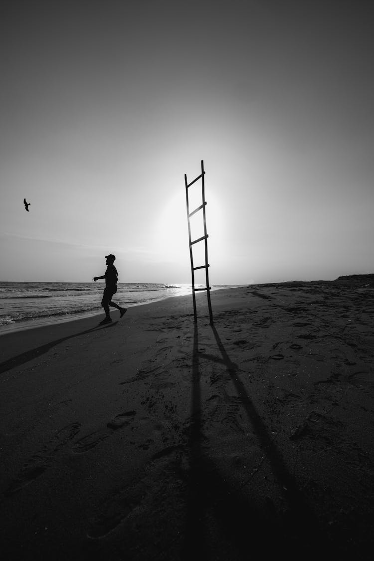 Man Running Near Ladder On Beach