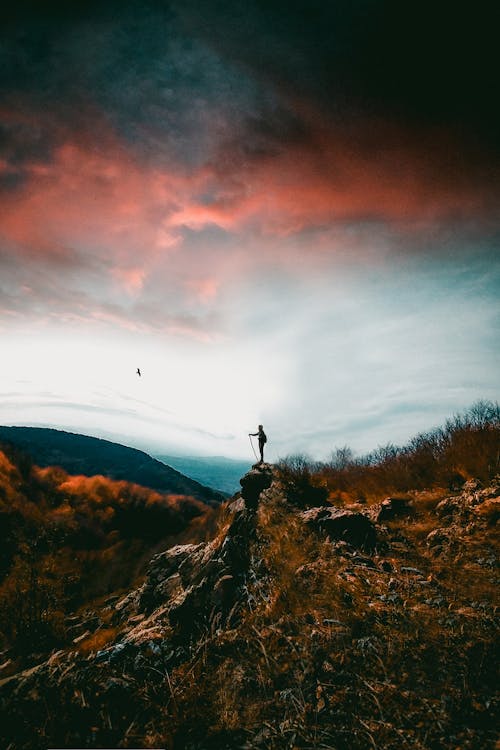 Person Standing on Top of a Mountain