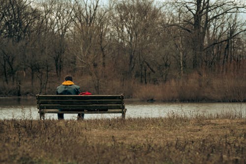 Man Sitting on Bench near River