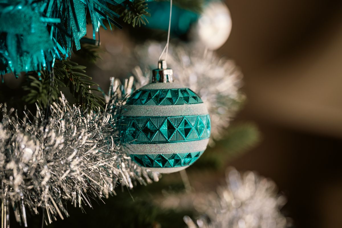 Blue ornament and silver garland close-up on a Christmas tree