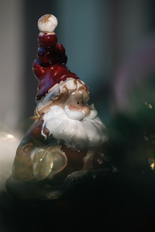 Free A ceramic Santa Claus figurine captured in a close-up shot with festive bokeh lighting effects. Stock Photo