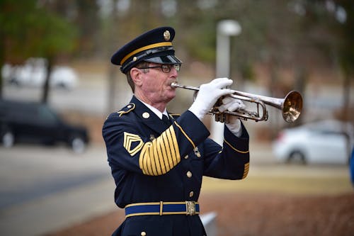 Man Wearing Military Uniform Playing Trumpet