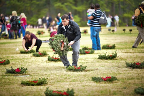A Man Putting Wreath on Headstone