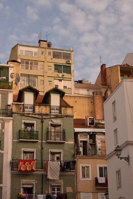 Colorful residential buildings in Lisbon, Portugal with laundry hanging from balconies.