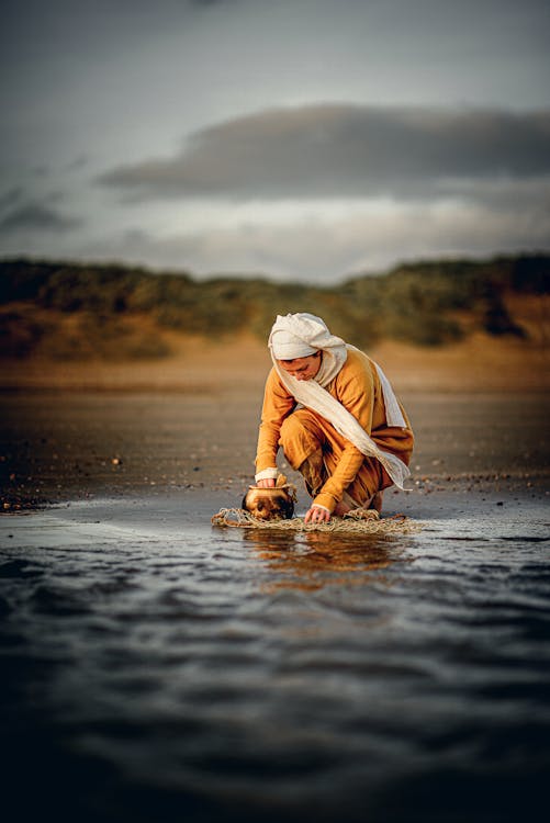 Woman Crouching on Sea Shore