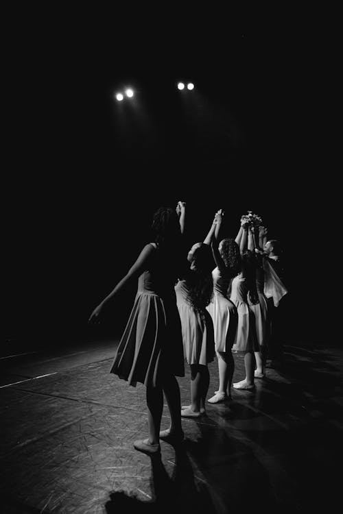 Grayscale Photo of Women Standing on Stage