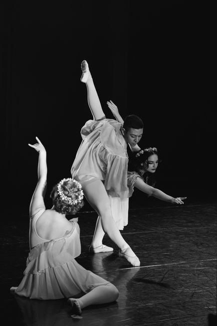 Black and white photo of a ballet trio performing on stage with graceful elegance.