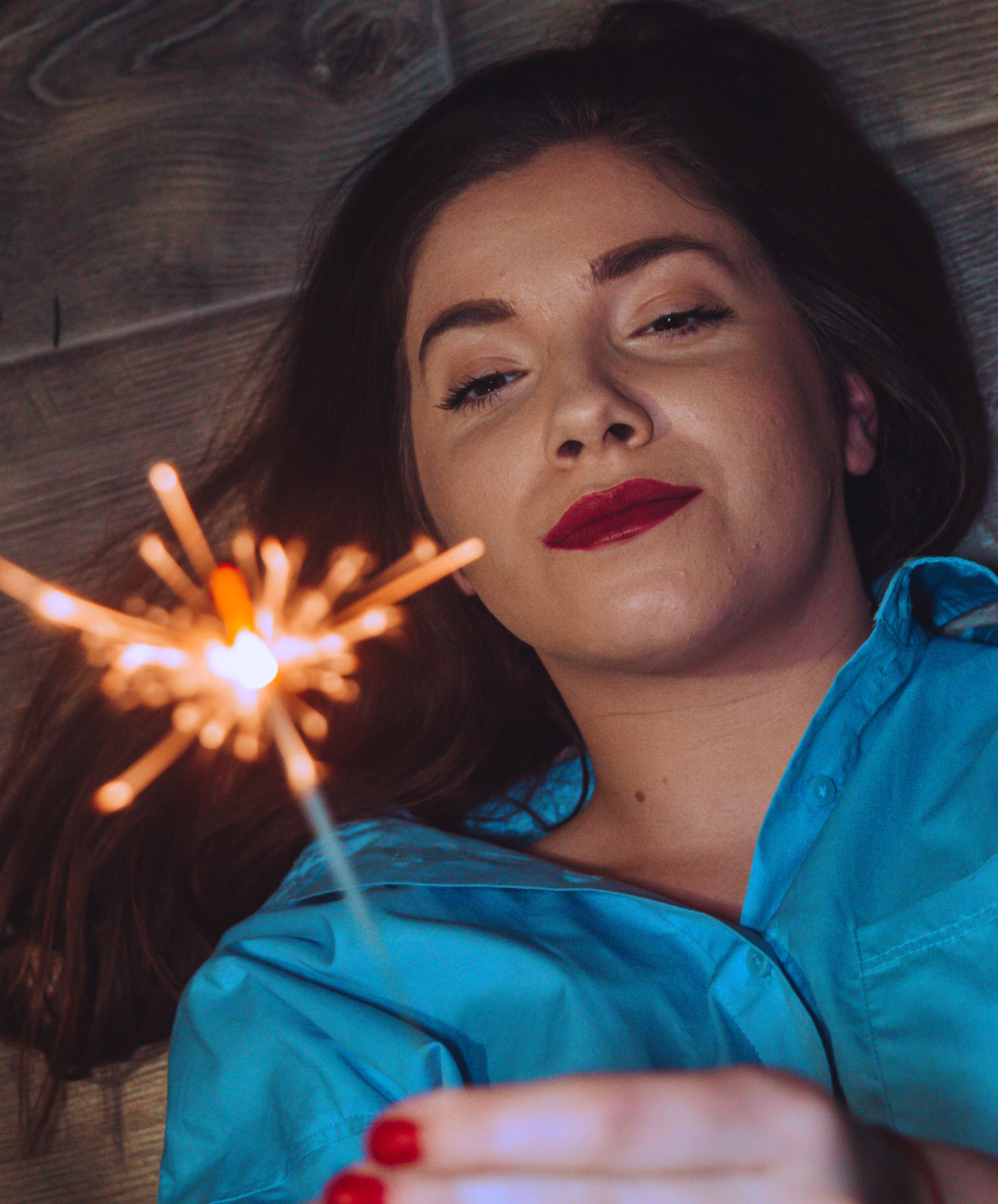 Woman Lying on the Floor Holding Firecracker · Free Stock Photo