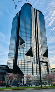 A striking modern skyscraper in Paris reflects the sky, showcasing architectural elegance.