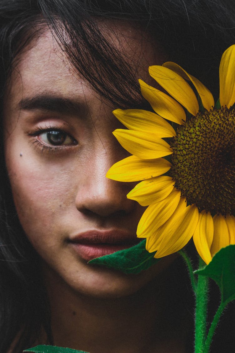 Girl Posing With Sunflower Near Face