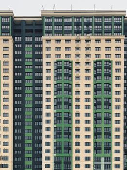 Contemporary skyscraper with green facade elements and multiple windows, ideal for urban themes.