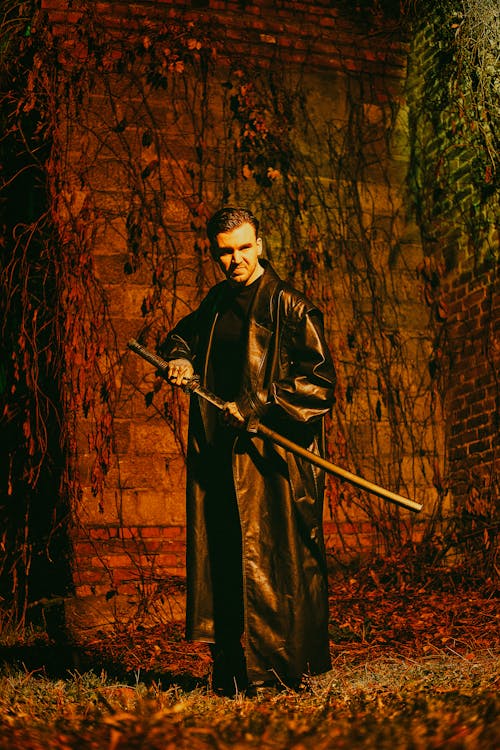 Free Man in Black Coat Holding a Sword Stock Photo