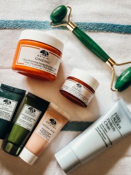 A selection of skincare products with a jade roller on a fabric background, perfect for beauty and wellness themes.