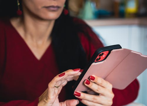 Free Woman in Red V Neck Shirt Holding Black Iphone 7 Plus Stock Photo