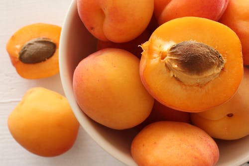 Kostenloses Stock Foto zu aprikose, auf einem weißen holztisch, frisches obst