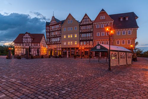 Free Charming cobblestone square with traditional German half-timbered buildings at dusk. Stock Photo