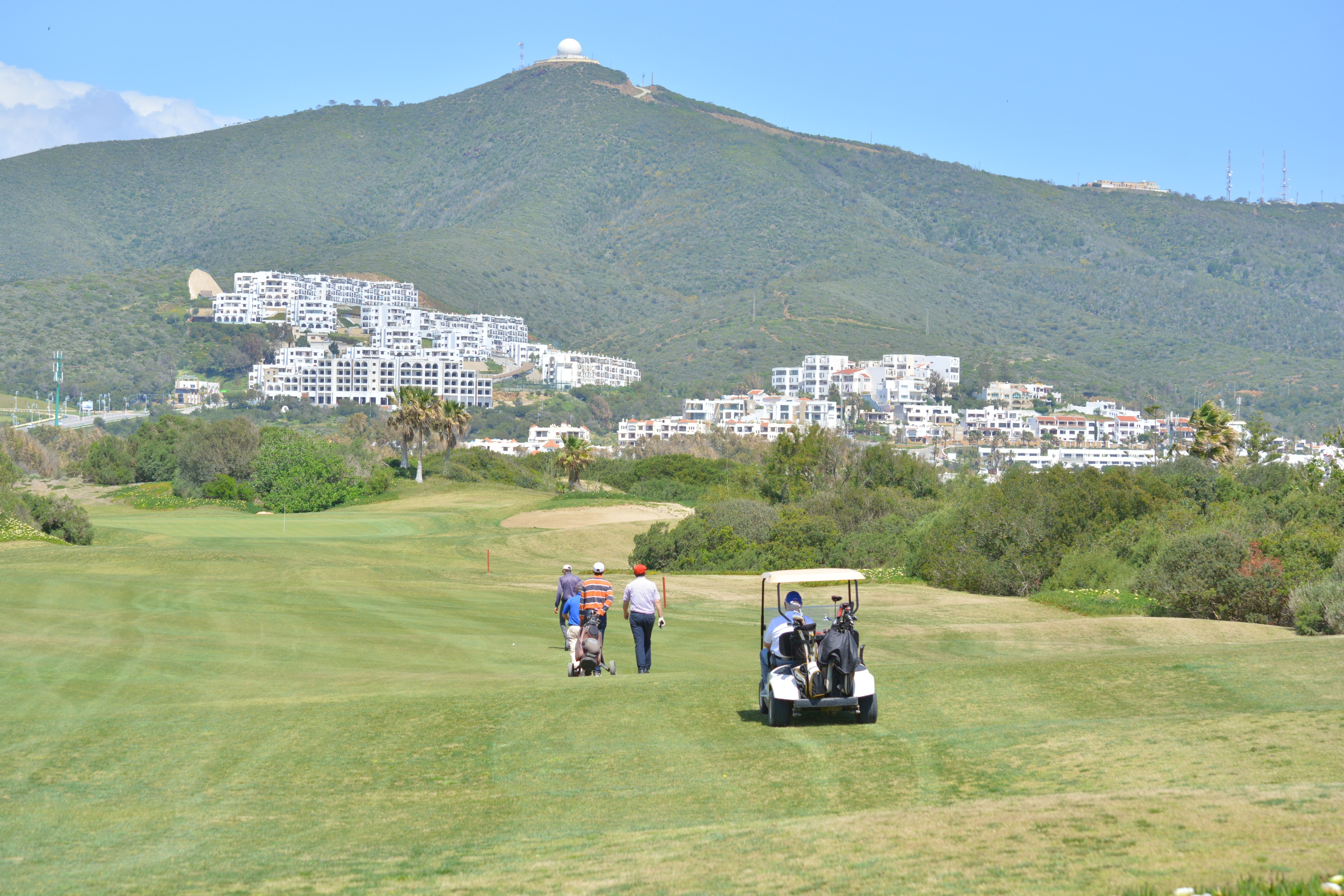 People on a Golf Course with a Scenic View of a Mountainside in Morocco