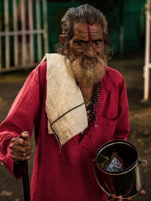 Elderly Man Holding a Steel Bucket