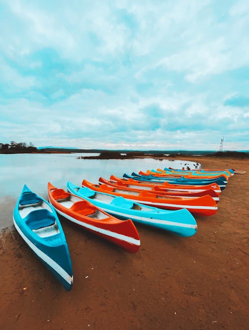 Free A Kayaks on Brown Sand Near the Body of Water Stock Photo